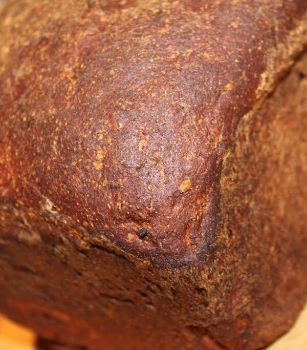 a loaf of flax seed bread on a wooden surface