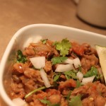 A bowl of everyday chole with a wedge of lemon
