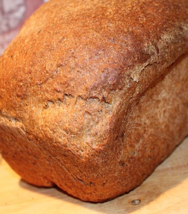 A Strawberry lemon flax seed bread loaf on a wooden cutting board