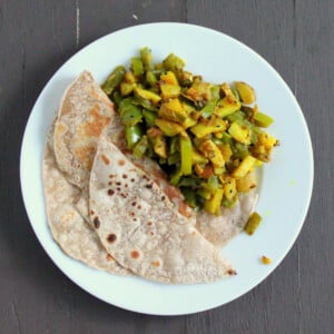 Saunf Aur Kalonji Waale Aloo Shimla Mirch served on a white plate with roti