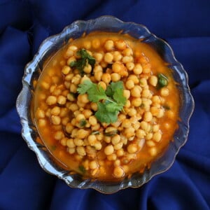 Imli chole served in a bowl on a dark blue background
