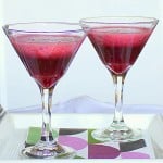 Two glasses of blueberry strawberry spiced cooler on a white background