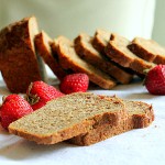 Slices of strawberry mango molasses loaf arranged with fresh strawberries