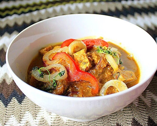 Tempeh Do Pyaaza served in a white bowl on a fabric background