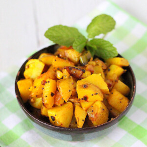 Potatoes with whole indian spices served in a bowl with cilantro garnish