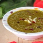 A bowl of creamy spinach soup on a wooden work top