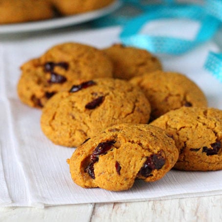Six muffin top cookies on some white fabric with a blue ribbon in the background