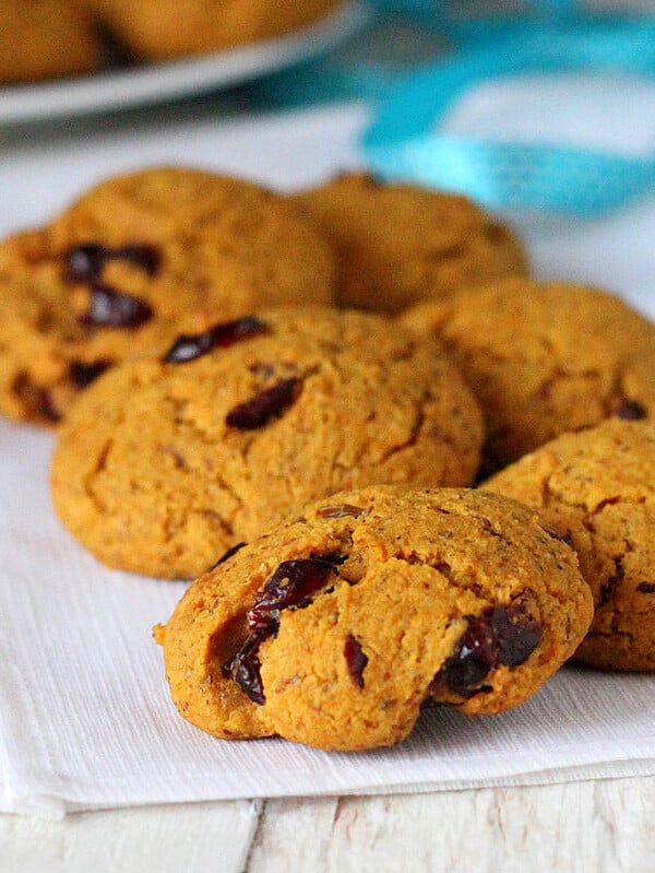 Six muffin top cookies on some white fabric with a blue ribbon in the background