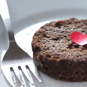 A closeup of chocolate cake on a white plate with a fork