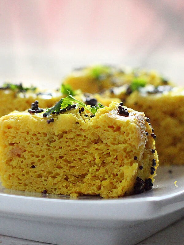 Khaman dhokla slices served on a white plate