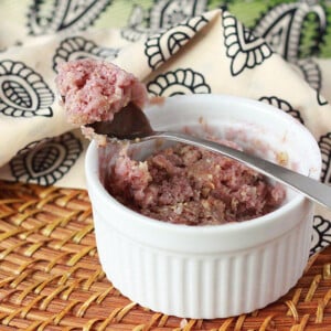 A blueberry coffee cake in a ramekin with a spoon resting on top