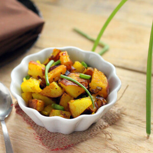 Potato Leet Subzi in a white bowl on a wooden work surface