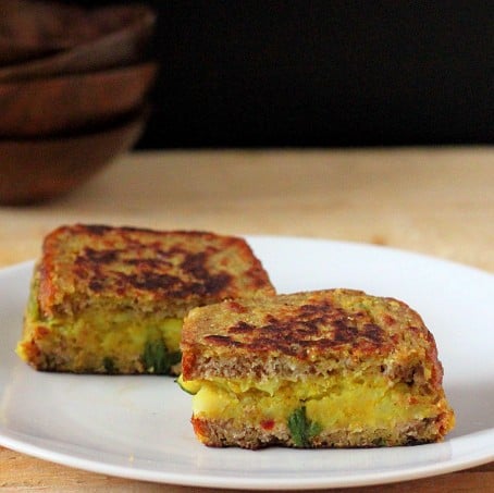 Stuffed French toasts served on a white plate and cut in half
