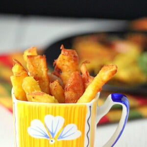Apple fritters served in a yellow and blue mug