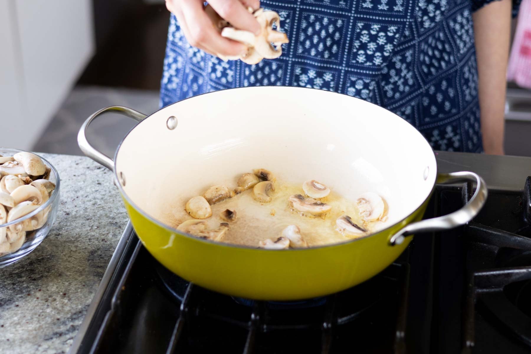 adding the mushrooms to the pan