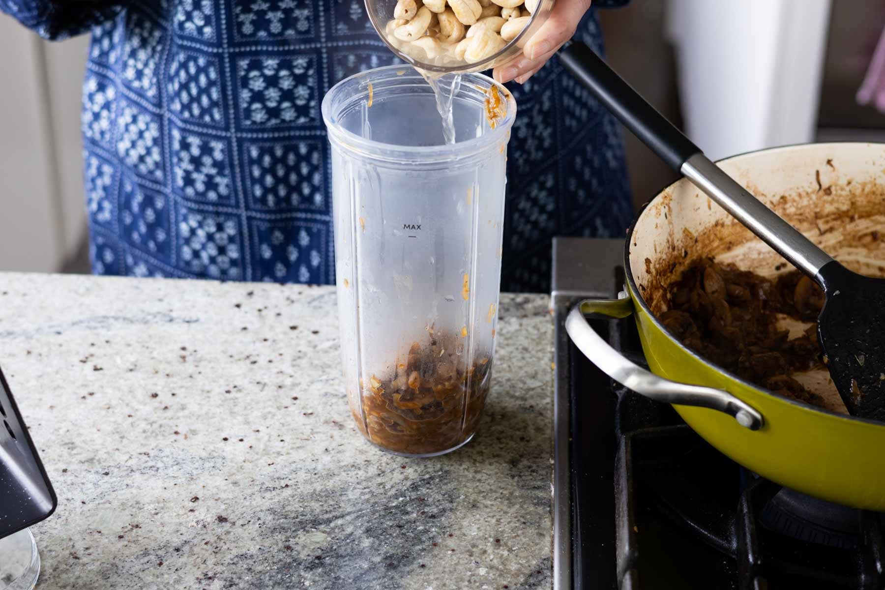 adding cashews to the blender