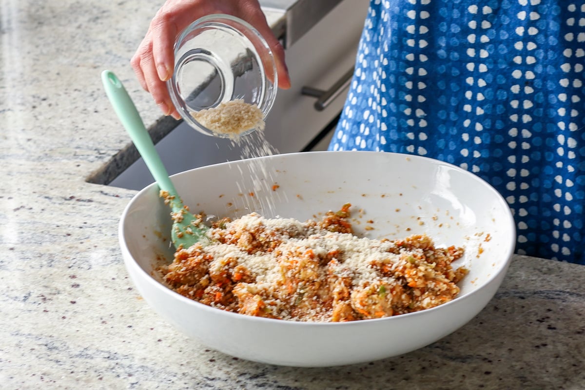 adding breadcrumbs to the BBQ lentil burger mixture in the bowl