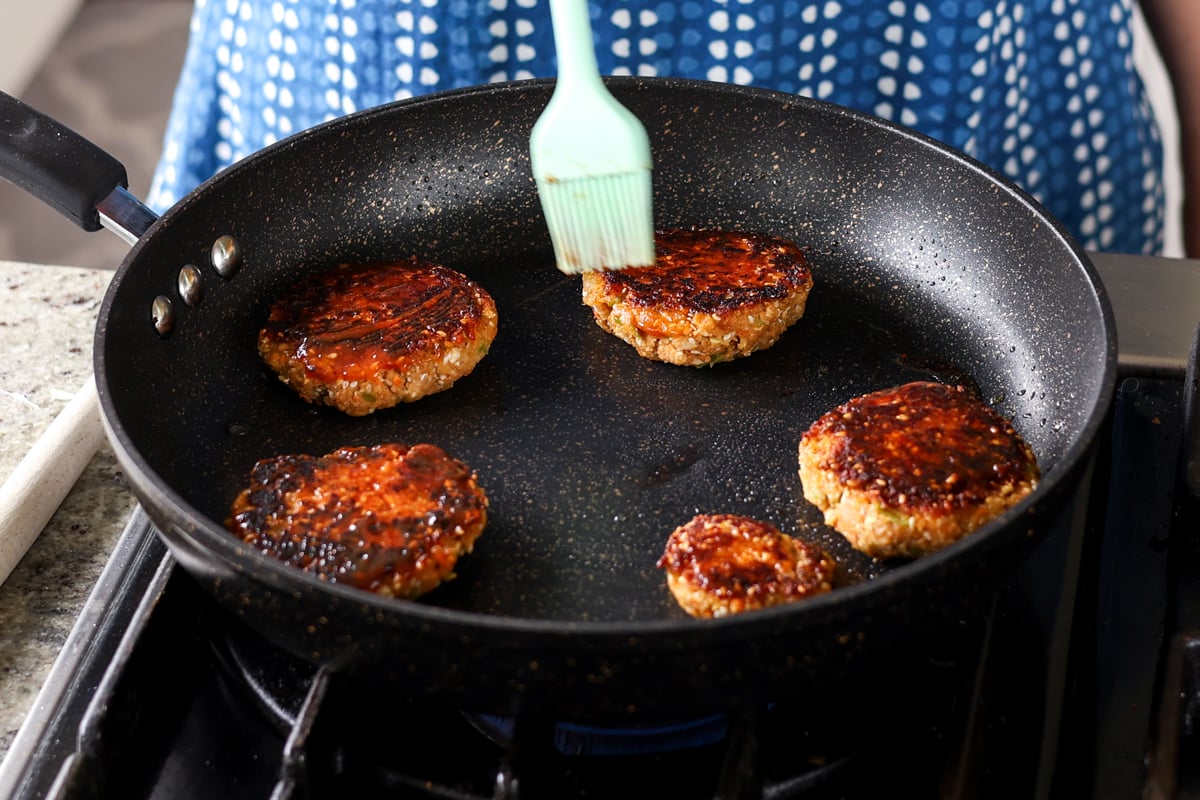 brushing more bbq sauce onto the burgers