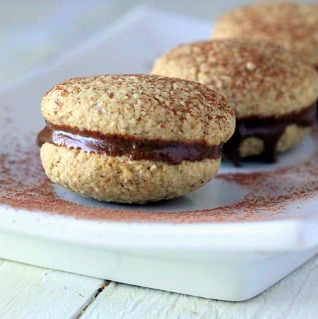 three tiramisu cookies on a white plate, dusted with cocoa powder