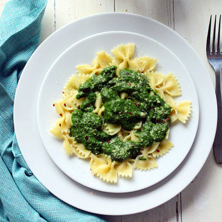 Farfalle with Swiss Chard Pesto served on a white plate with a blue cloth