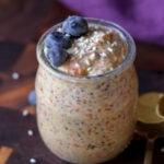 carrot cake overnight oats in a jar with blueberries on top