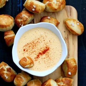 Vegan Pretzel Bites on wooden board with spicy mustard dip in white bowl