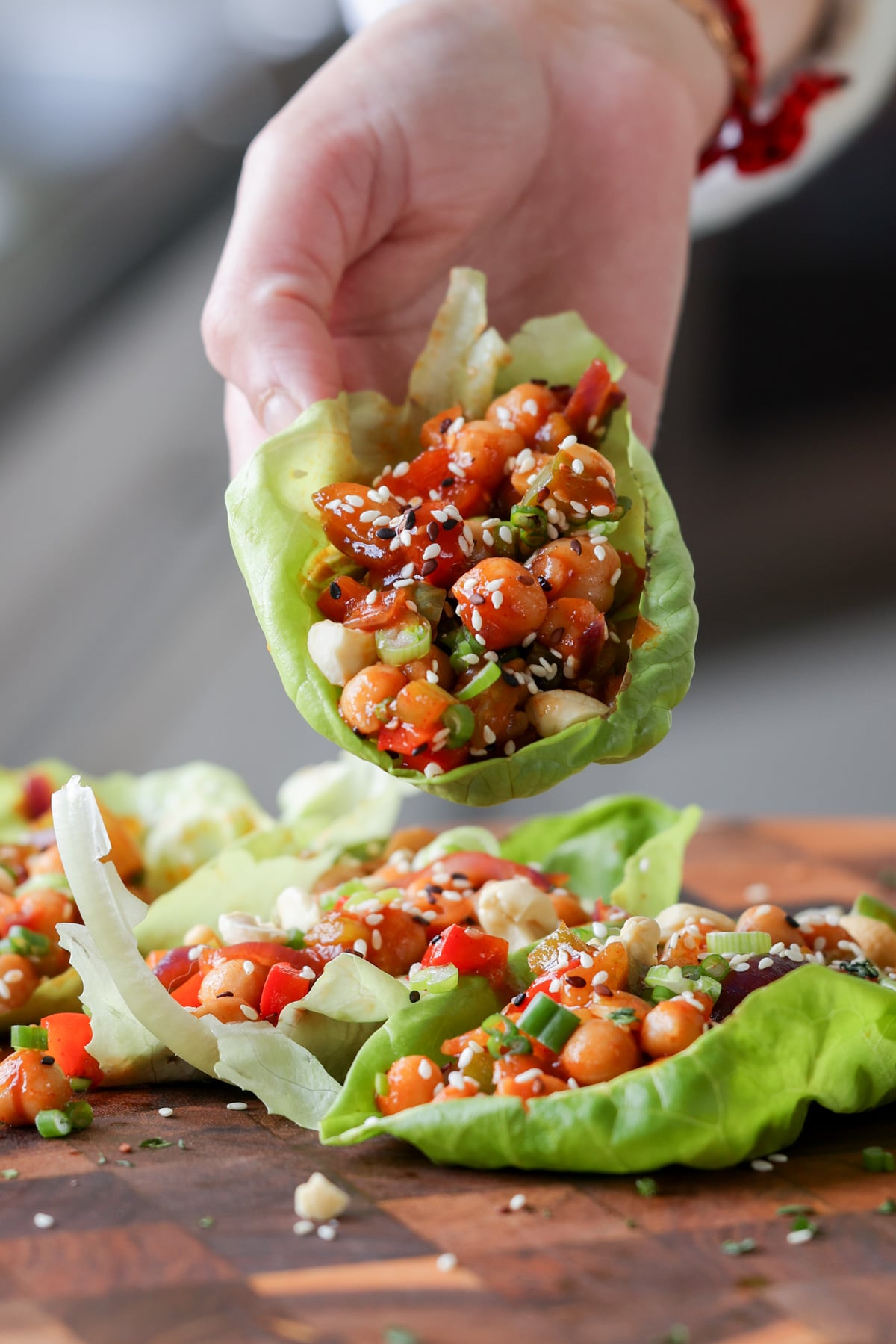 hand holding gochujang chickpeas lettuce wraps