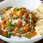 close-up of butter tofu paneer in a bowl with naan