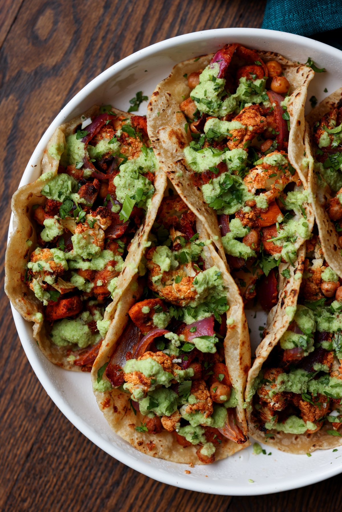 cauliflower sweet potato tacos on a plate with coconut chutney and garnishes