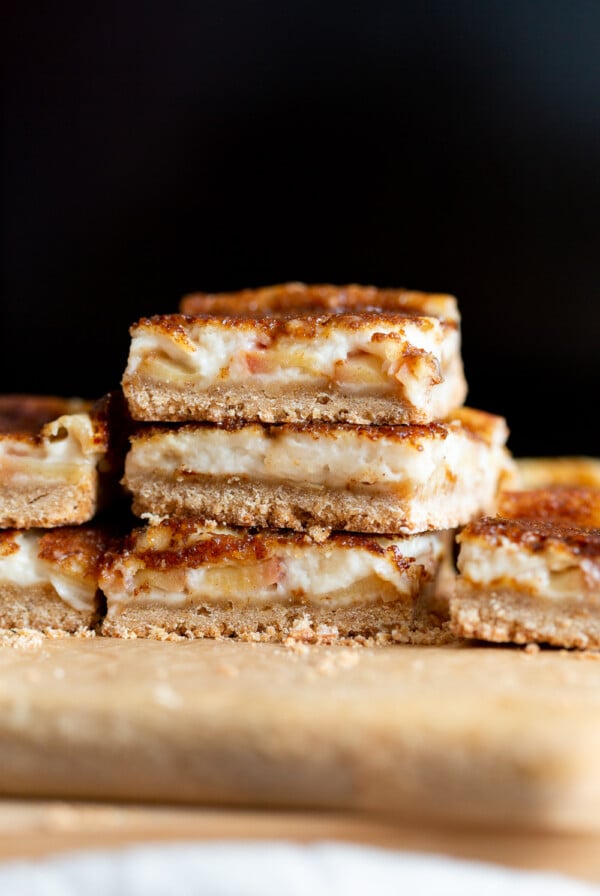 Sliced Vegan Apple Custard Squares stacked on wood board