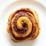 overhead shot of a vegan no yeast cinnamon roll with sweet potato on a white plate