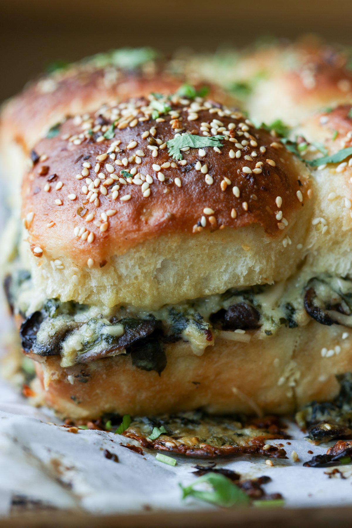 close-up of cheesy mushroom sliders on the baking sheet after baking