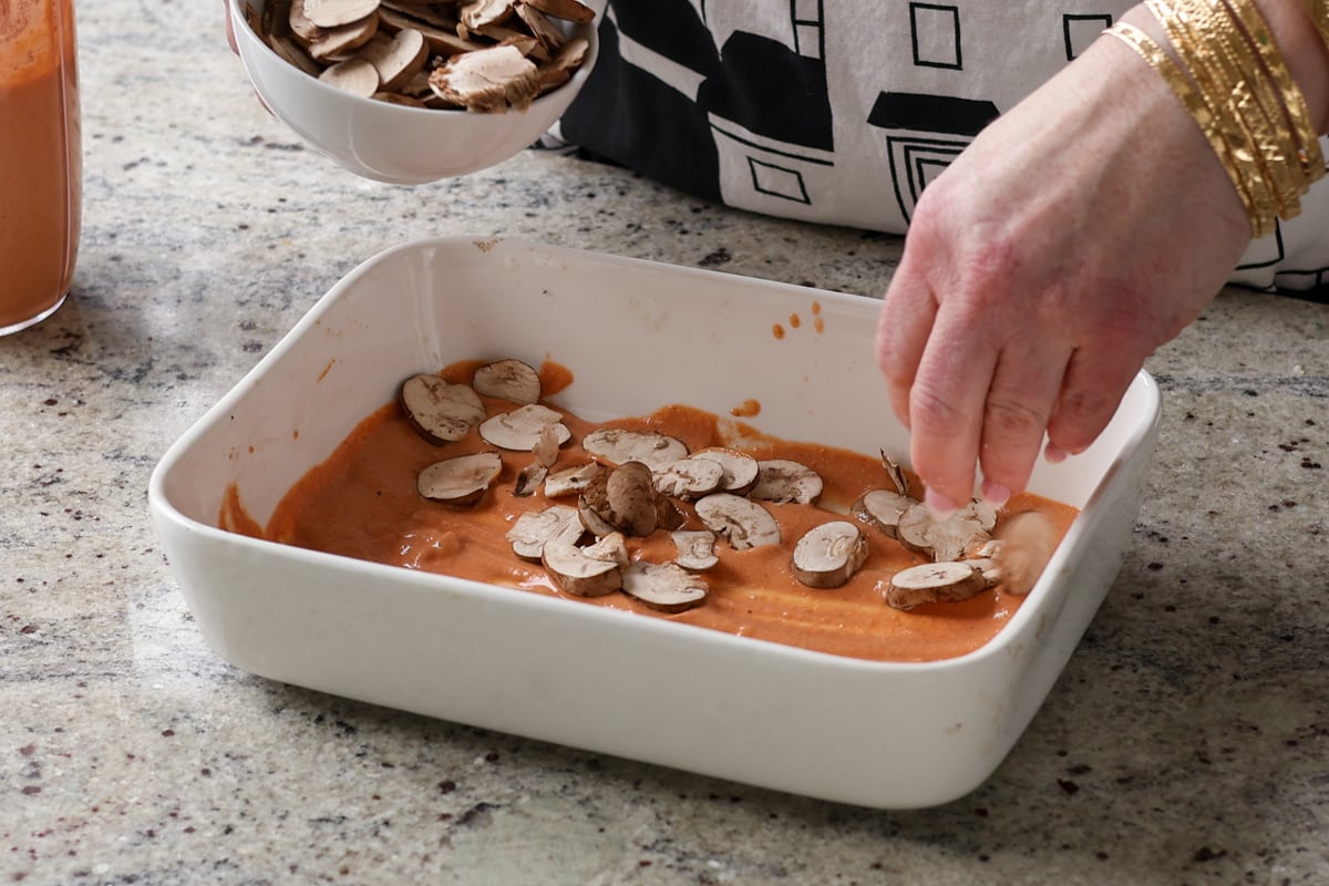 adding mushrooms to the baking dish