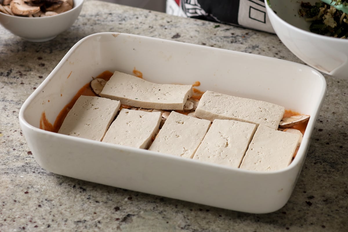 adding tofu to the baking dish
