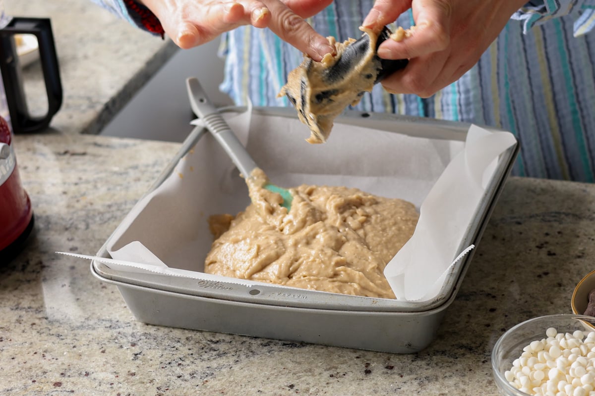 adding the batter to a lined baking pan