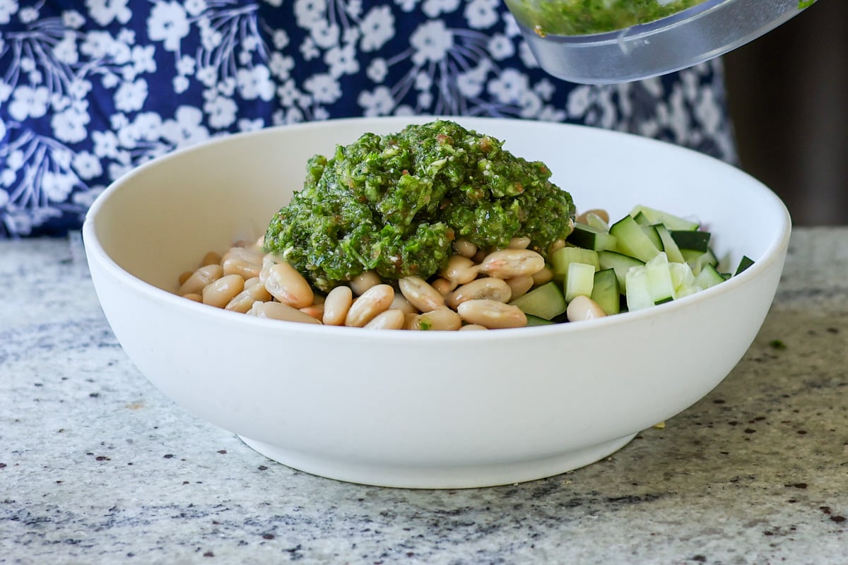 adding green chutney to the beans and veggies