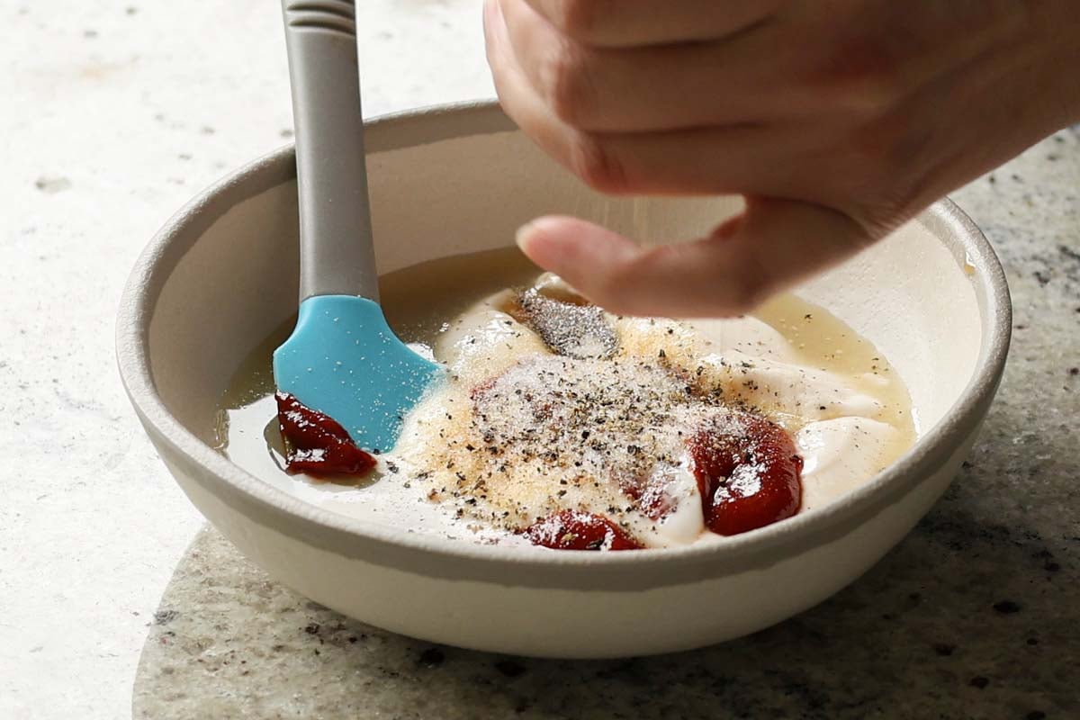 adding yum sauce ingredients to the bowl