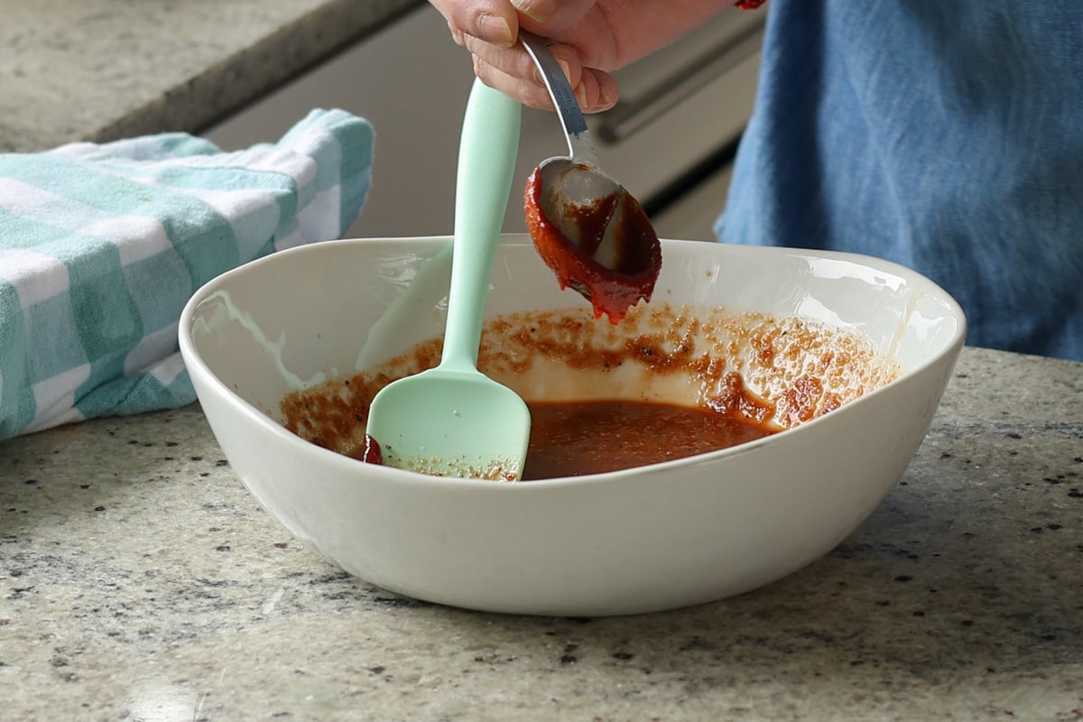 adding gochujang tofu marinade ingredients to a bowl
