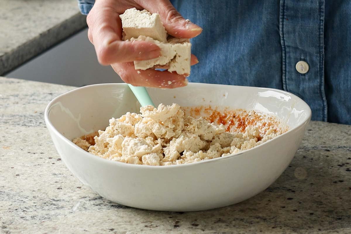crumbling tofu into the bowl