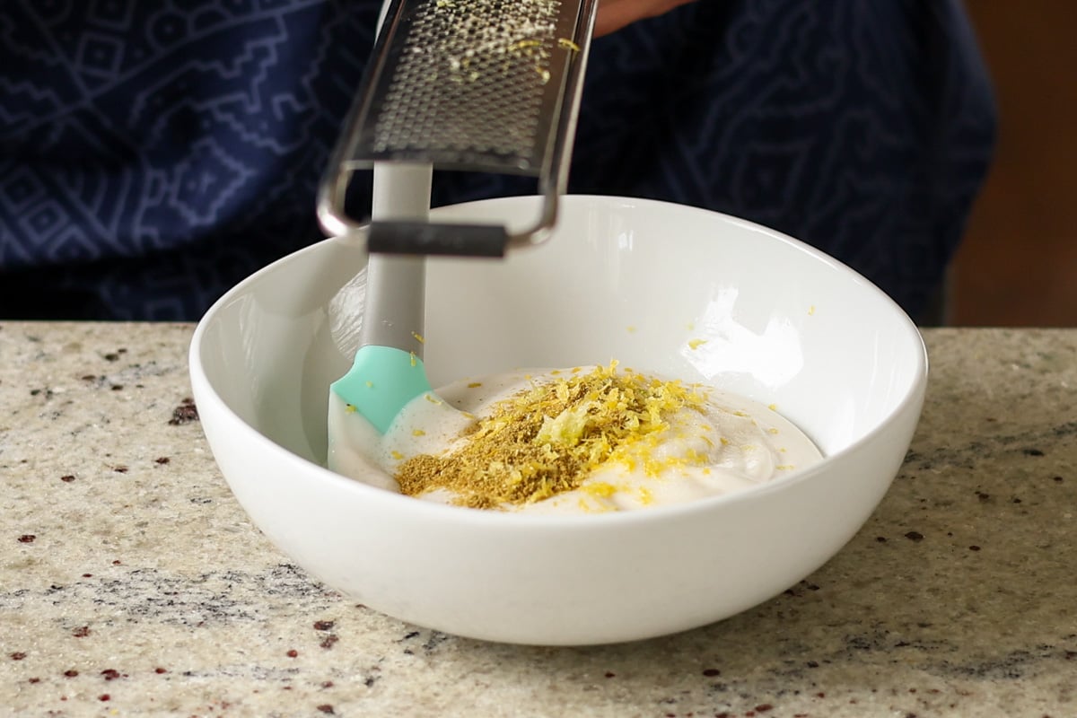 adding yogurt sauce ingredients to the bowl