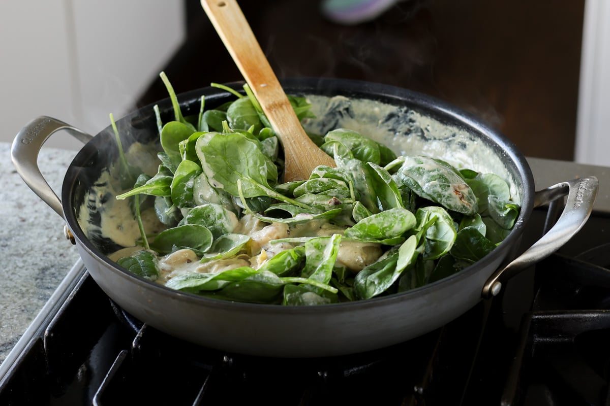 adding spinach to the pan