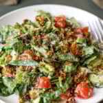 summer spinach salad with chickpea olive crumbles on a plate with a fork