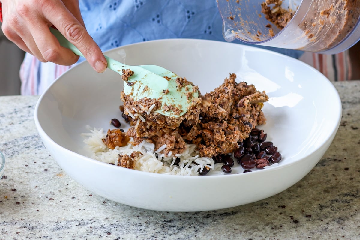 Black beans and rice mixed with veggie patty mix in a white bowl.