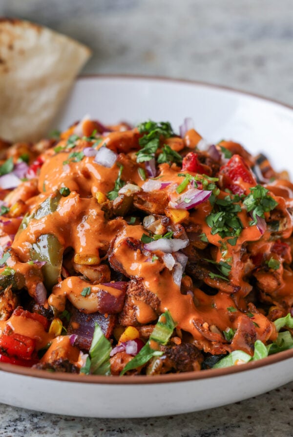 cajun sheet pan beans veggies in a bowl with pita