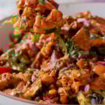 spoon taking a bite of cajun sheet pan beans veggies