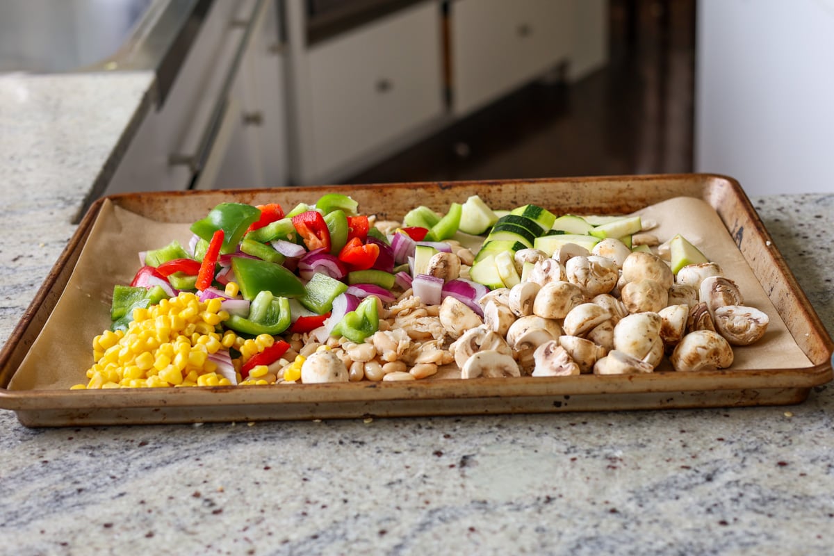 adding the veggies to the sheet pan