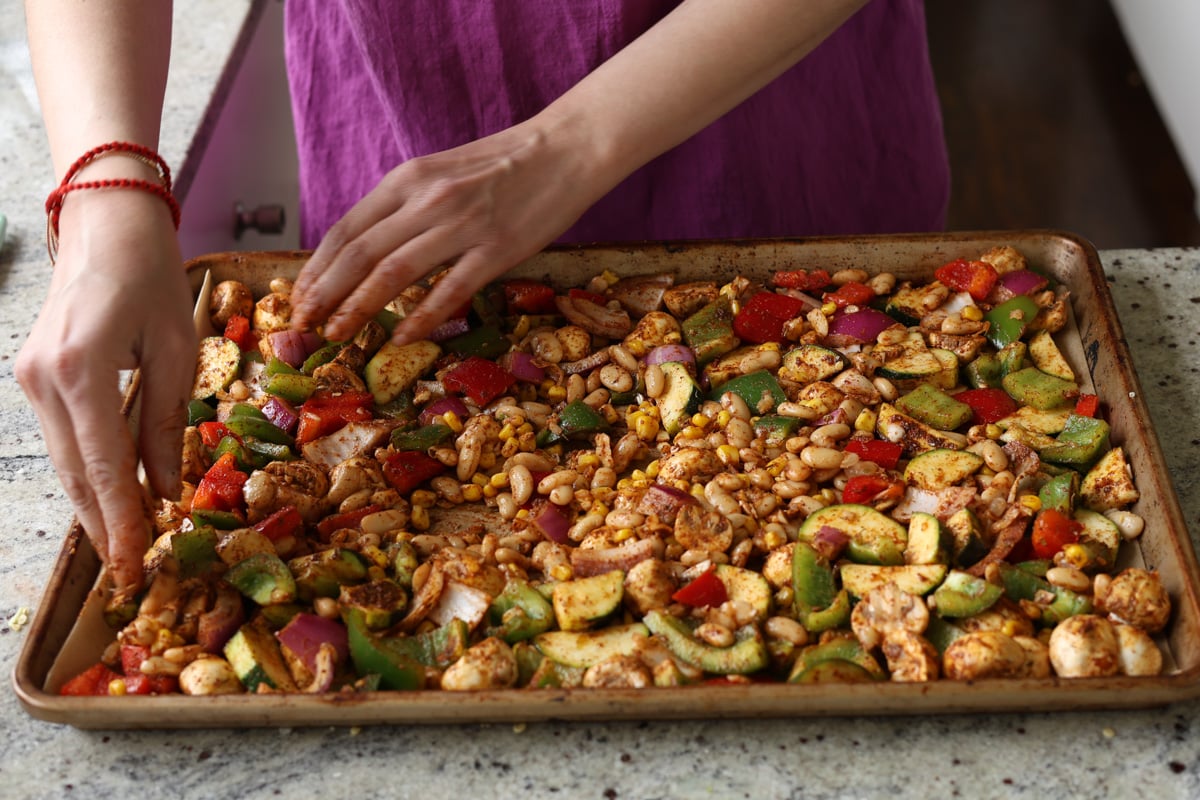 tossing beans and veggies in spices and sauce