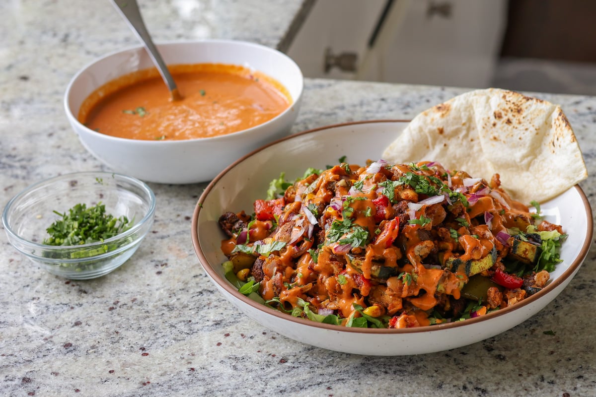 cajun sheet pan beans veggies in the bowl after adding dressing