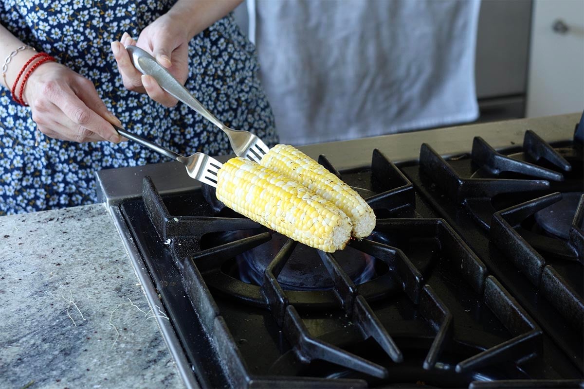 roasting corn over gas flame