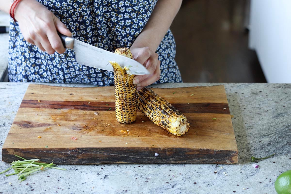 cutting the corn off of the cob